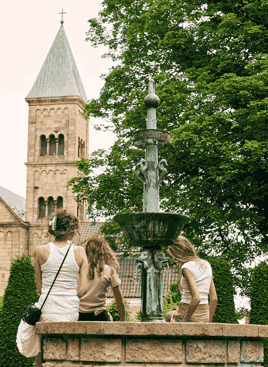 Viborg Domkirke set fra Latinerhaven, hvor en familie sidder ved et springvand. foto: Nikolai Frantzen
